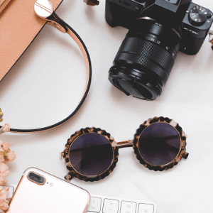 top down photo of a camera and feminine accessories