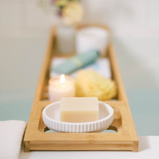 variety of bath products in a wooden tray - self care ideas for moms