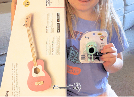 girl holding loog guitar pro and monster tuner