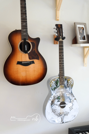 acoustic and resonator guitar hanging on wall