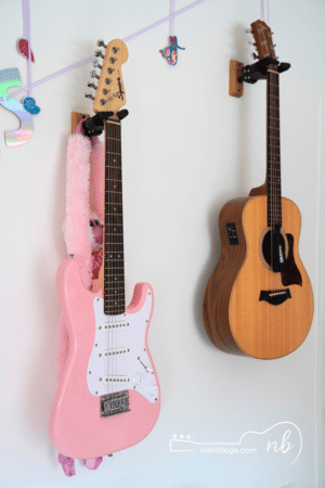 bedroom wall with two hanging guitars