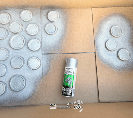 snow glove mason jar tops being spray painted