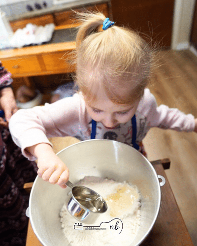 toddler pouring egg white into a bowl