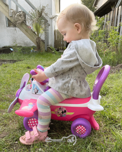 toddler girl playing on ride on airplane toy