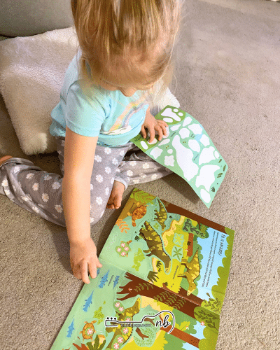 toddler putting stickers into a sticker book